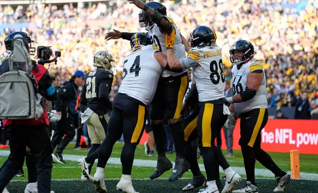 Pittsburgh Steelers tight end Darnell Washington (80), top center, celebrates with teammates after scoring the opening touchdown during an NFL football game against New Orleans Saints in Saint-Denis, outside Paris, Sunday, Oct. 25, 2026. (AP Photo/Steve Luciano)