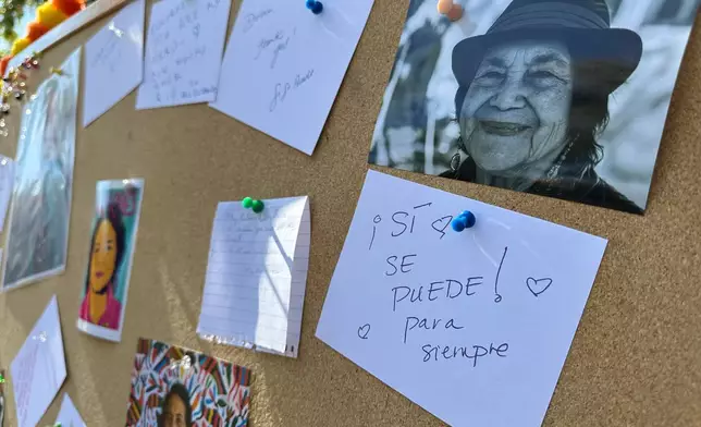 In this photo made with a smartphone, photographs and handwritten messages are part of an altar set up in honor of Dolores Huerta at Old Town Plaza in Albuquerque, New Mexico, Wednesday, Oct. 28, 2026. (AP Photo/Susan Montoya Bryan)