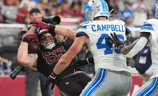 Arizona Cardinals tight end Trey McBride (85) catches a touchdown pass as Detroit Lions linebacker Jack Campbell (46) defends during the second half of an NFL football game in Glendale, Ariz., Sunday, Oct. 11, 2026. (AP Photo/Ross D. Franklin)