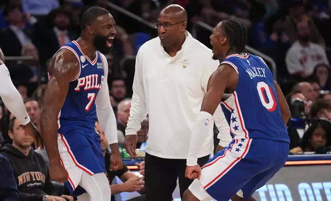 Philadelphia 76ers guard Jaylen Brown, left, celebrates a three-point basket with teammate guard Tyrese Maxey, right, as New York Knicks head coach Mike Brown looks on, center, during the second half of an NBA basketball game Tuesday, Oct. 20, 2026, in New York. (AP Photo/Frank Franklin II)