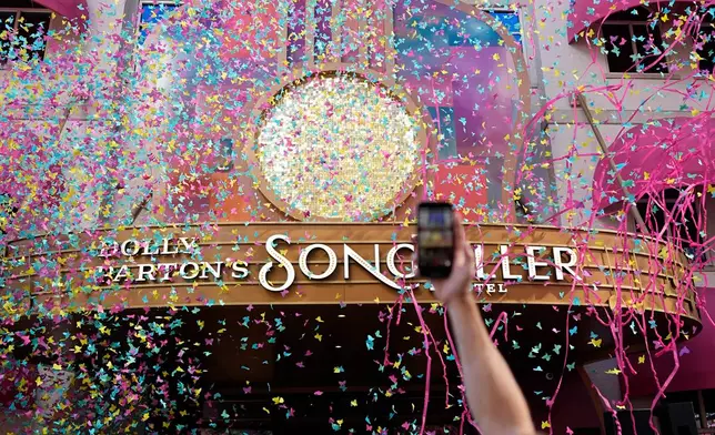 Confetti flies in the air outside Dolly Parton's Songteller Hotel during a grand opening ceremony Tuesday, Oct. 6, 2026, in Nashville, Tenn. (AP Photo/George Walker IV)