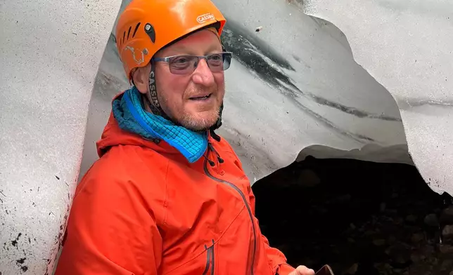 Andrej Slak, a mountain guide, stands next to remaining ice at the Skuta glacier near Kamnik, Slovenia, Oct. 11, 2026. (AP Photo)