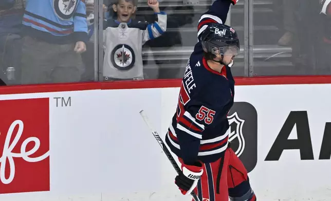 Winnipeg Jets' Mark Scheifele (55) celebrates his goal against the Minnesota Wild during first period NHL hockey action in Winnipeg, Manitoba, Tuesday, Oct. 13, 2026. (Fred Greenslade/The Canadian Press via AP)