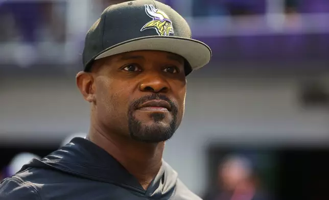 FILE - Minnesota Vikings defensive coordinator Brian Flores watches during warm ups before an NFL preseason football game against the Baltimore Ravens, Aug. 22, 2026, in Minneapolis. (AP Photo/Bruce Kluckhohn, File)