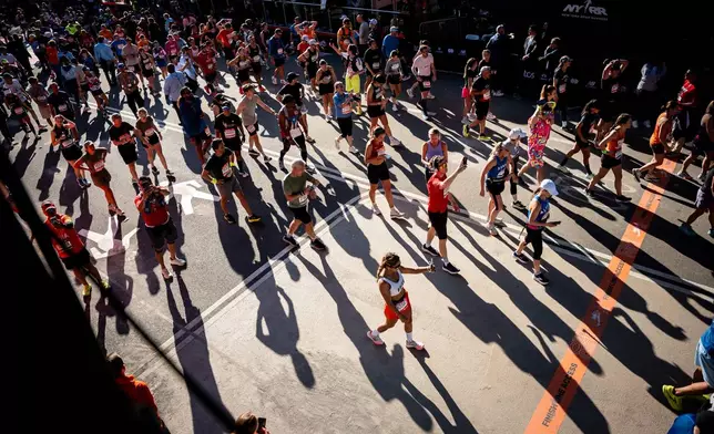 FILE - Runners cross the finish line in Central Park during the New York City Marathon, Sunday, Nov. 2, 2025, in New York. (AP Photo/Angelina Katsanis, File)