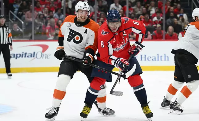 Washington Capitals left wing Alex Ovechkin (8) and Philadelphia Flyers defenseman Travis Sanheim (6) battle for the puck during the first period of an NHL hockey game, Wednesday, Oct. 28, 2026, in Washington. (AP Photo/Nick Wass)