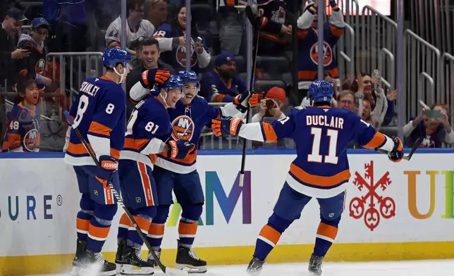 New York Islanders left wing Ondrej Palat (81) is congratulated by teammates after scoring a goal during the first period of an NHL hockey game against the Anaheim Ducks, Tuesday, Oct. 20, 2026, in Elmont, N.Y. (AP Photo/Adam Hunger)