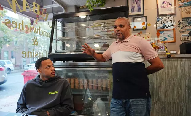 Alberto Pena who operates Las Palmas Restaurant that serves Dominican food, speaks as his son Miguel, looks on in Allentown, Pa., on Sept. 29, 2026. (AP Photo/Matt Rourke)