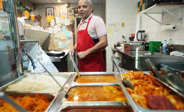 Alberto Pena who operates Las Palmas Restaurant that serves Dominican food, puts on his apron at the business he operates in Allentown, Pa., on Sept. 29, 2026. (AP Photo/Matt Rourke)