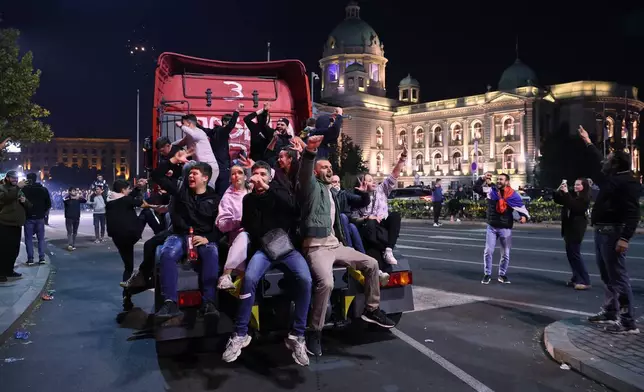 People celebrate outside the National Assembly, after Aleksandar Vucic, leader of the right-wing Serbian Progressive Party (SNS) conceded defeat in the parliamentary election in Belgrade, Serbia, early Monday, Oct. 26, 2026. (AP Photo/Armin Durgut)