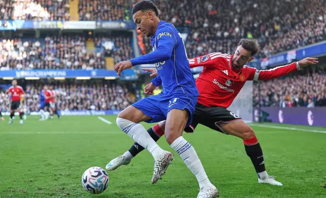 Manchester United's Bruno Fernandes, right, challenges for the ball with Chelsea's Morgan Rogers during the English Premier League soccer match between Chelsea and Manchester United in London, Saturday, Oct. 31, 2026. (AP Photo/Ian Walton)