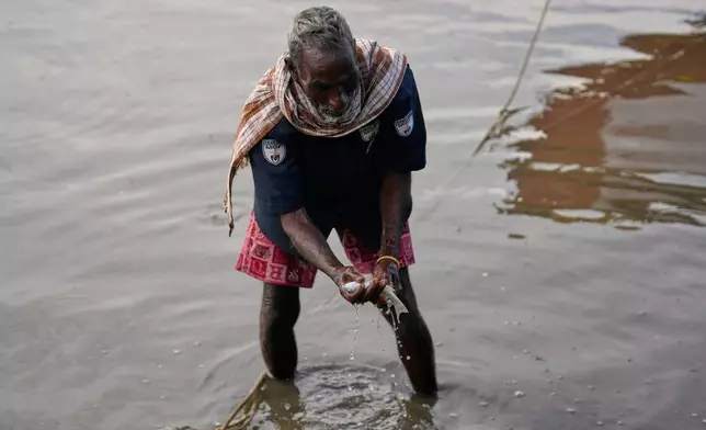 A fisherman fishes in the backwaters in Kakinada, India, Thursday, Oct. 29, 2026, a day after Cyclone Arnab crossed the Andhra Pradesh coast. (AP Photo/Mahesh Kumar A.)