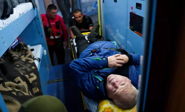 Red Cross volunteers move a man with a disability on a stretcher into an ambulance during an evacuation to a safe area amid a local ceasefire linked to a humanitarian aid mission in Oleshky, in Ukraine's Kherson region, Thursday, Oct. 29, 2026. (AP Photo/Evgeniy Maloletka)