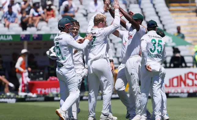 South Africa's Simon Harmer celebrates with teammates the wicket of Australia's Marnus Labuschagne, on day two of the third cricket test match between South Africa and Australia, in Cape Town, South Africa, Wednesday, Oct. 28, 2026. (AP Photo/Halden Krog)