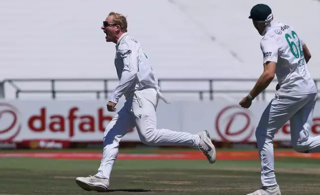 South Africa's Simon Harmer celebrates with teammates the wicket of Australia's Marnus Labuschagne, on day two of the third cricket test match between South Africa and Australia, in Cape Town, South Africa, Wednesday, Oct. 28, 2026. (AP Photo/Halden Krog)