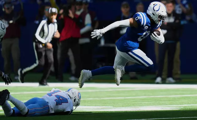 Indianapolis Colts safety Cam Bynum (0) returns an interception past Tennessee Titans wide receiver Carnell Tate (14) during the first half of an NFL football game Sunday, Oct. 18, 2026, in Indianapolis. (AP Photo/AJ Mast)
