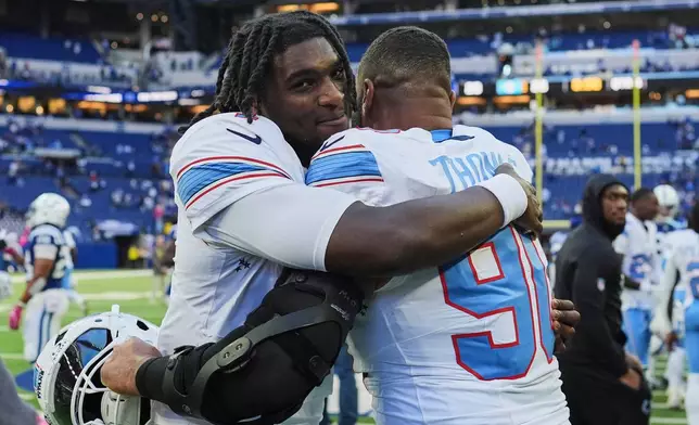 Tennessee Titans quarterback Cam Ward, left, celebrates the team's wins with defensive tackle Solomon Thomas (90) after an NFL football game against the Indianapolis Colts, Sunday, Oct. 18, 2026, in Indianapolis. (AP Photo/Jeff Roberson)