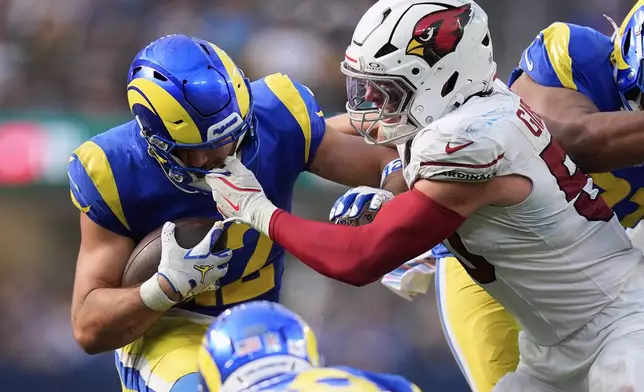 Los Angeles Rams wide receiver Puka Nacua, left, has his face mask grabbed by Arizona Cardinals linebacker Jack Gibbens during the second half of an NFL football game in Inglewood, Calif., Sunday, Oct. 18, 2026. (AP Photo/Gregory Bull)