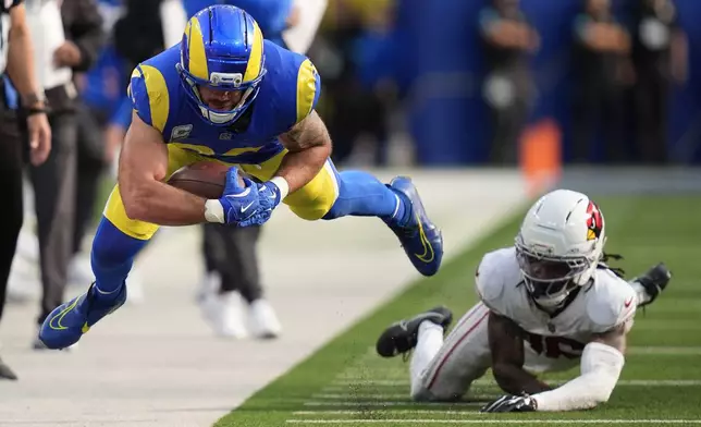 Los Angeles Rams tight end Tyler Higbee, left, dives forward in front of Arizona Cardinals cornerback Max Melton during the second half of an NFL football game in Inglewood, Calif., Sunday, Oct. 18, 2026. (AP Photo/Gregory Bull)