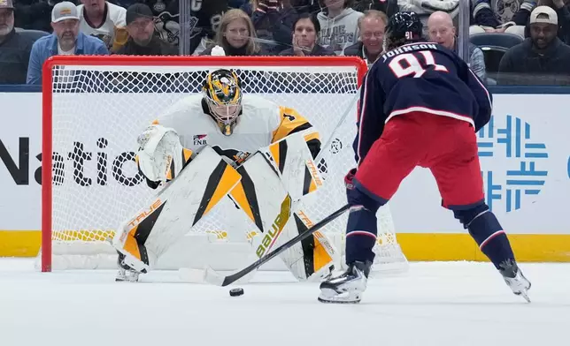 Columbus Blue Jackets center Kent Johnson (91) scores on Pittsburgh Penguins goaltender Sergei Murashov (1) in a shootout in an NHL hockey game in Columbus, Ohio, Friday, Oct. 9, 2026. (AP Photo/Sue Ogrocki)