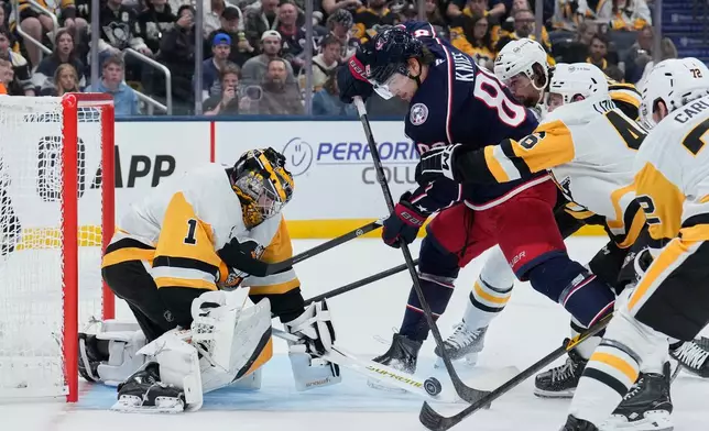 Pittsburgh Penguins goaltender Sergei Murashov (1) blocks a shot by Columbus Blue Jackets left wing Matthew Knies, center, in the second period of an NHL hockey game in Columbus, Ohio, Friday, Oct. 9, 2026. (AP Photo/Sue Ogrocki)