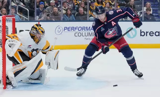 Pittsburgh Penguins goaltender Sergei Murashov (1) blocks a shot next to Columbus Blue Jackets center Charlie Coyle (3) in the second period of an NHL hockey game in Columbus, Ohio, Friday, Oct. 9, 2026. (AP Photo/Sue Ogrocki)