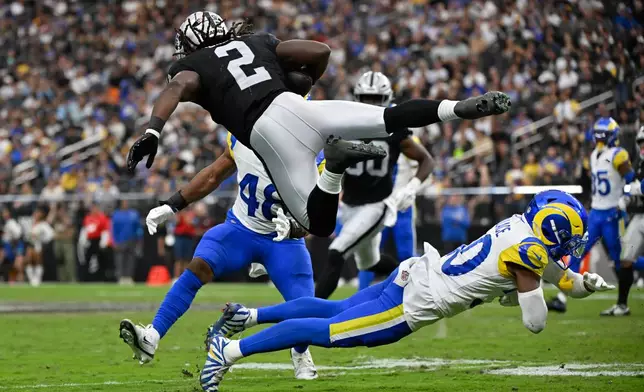Las Vegas Raiders running back Ashton Jeanty (2) is tripped up by Los Angeles Rams cornerback Josh Wallace during the second half of an NFL football game Sunday, Oct. 25, 2026, in Las Vegas. (AP Photo/David Becker)