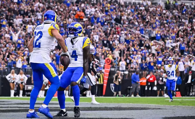 Los Angeles Rams wide receiver Puka Nacua, left, celebrates after scoring a touchdown with teammate Konata Mumpfield during the first half of an NFL football game against the Las Vegas Raiders, Sunday, Oct. 25, 2026, in Las Vegas. (AP Photo/David Becker)