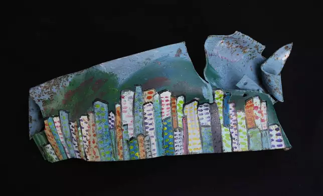 An artwork depicting a city skyline, created by visual artist Lina Jouni from shrapnel collected from Israeli military munitions, is displayed at her home in the village of Roumin, southern Lebanon, Sunday, Oct. 25, 2026. (AP Photo/Hassan Ammar)