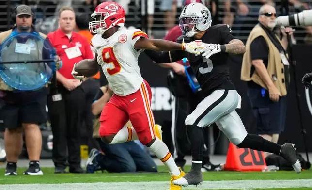 Kansas City Chiefs running back Kenneth Walker (9) runs as Las Vegas Raiders cornerback Taron Johnson (3) defends during the second half of an NFL football game in Las Vegas, Sunday, Oct. 4, 2026. (AP Photo/John Locher)