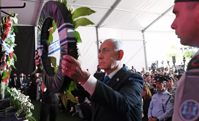 Israel's Prime Minister Benjamin Netanyahu, center, lays a wreath during a state memorial ceremony in memory of those killed in the Oct. 7, 2023, Hamas attack on Israel, at Mount Herzl Cemetery in Jerusalem, Monday, Oct. 5, 2026. (Debbie Hill/Pool Photo via AP) ADDITION: Adds context of memorial ceremony.