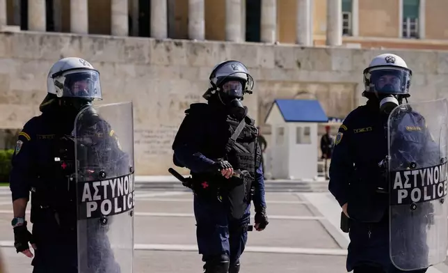 Greek police stand in front the parliament during a protest organized by teachers and students demanding improvements to education and measures to address the rising cost of living in Athens, Greece, Wednesday, Oct. 21, 2026. (AP Photo/Thanassis Stavrakis)