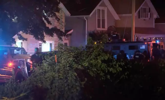 In this image from video provided by WJET, police gather outside the scene of a shooting in Erie, Pa., on Friday evening, Oct. 9, 2026. (Matt Barnum/WJET via AP)