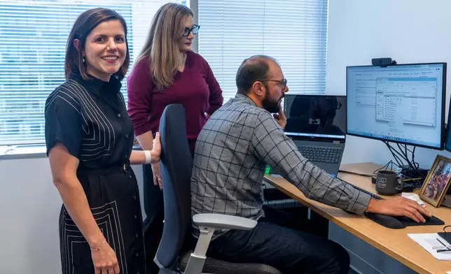 Smithsonian Institution's Chief Digital and Innovation Officer Becky Kobberod, from left, and her team Sara Snyder, director of Digital Experience and Data Scientist Mike Trizna, gather in Trizna's office Sept. 29, 2026, in Washington. (AP Photo/Manuel Balce Ceneta)
