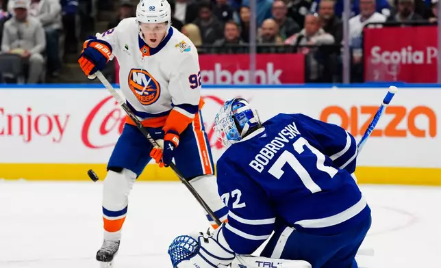 Toronto Maple Leafs goaltender Sergei Bobrovsky (72) makes a save as New York Islanders' Simon Holmstrom (92) looks for the rebound during the first period of an NHL hockey game in Toronto, Saturday, Oct. 17, 2026. (Frank Gunn/The Canadian Press via AP)
