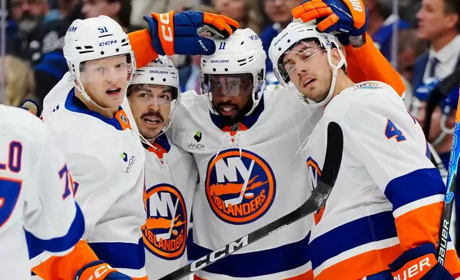 New York Islanders' Anthony Duclair (11) celebrates his goal against the Toronto Maple Leafs with Emil Heineman (51), Jean-Gabriel Pageau (44) and Matthew Kessel (4) during the first period of an NHL hockey game in Toronto, Saturday, Oct. 17, 2026. (Frank Gunn/The Canadian Press via AP)