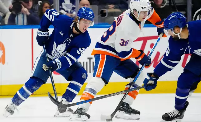 Toronto Maple Leafs' Gavin McKenna (92) chases New York Islanders' Victor Eklund (38) during the first period of an NHL hockey game in Toronto, Saturday, Oct. 17, 2026. (Frank Gunn/The Canadian Press via AP)
