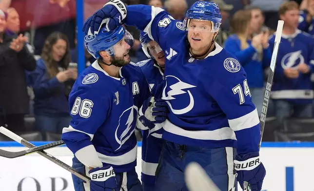 Tampa Bay Lightning defenseman John Carlson (74) celebrates his goal against the Minnesota Wild with right wing Nikita Kucherov (86) during the second period of an NHL hockey game Thursday, Oct. 8, 2026, in Tampa, Fla. (AP Photo/Chris O'Meara)