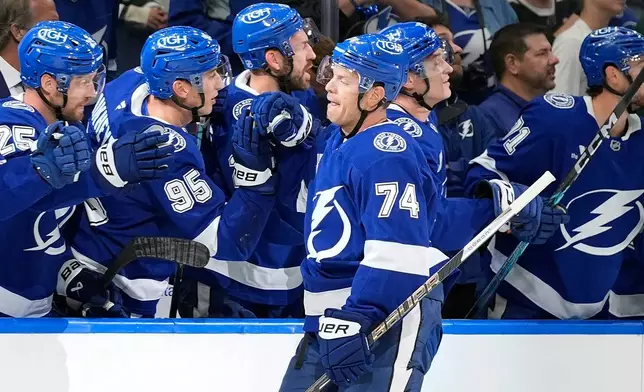 Tampa Bay Lightning defenseman John Carlson (74) celebrates with the bench after his goal against the Minnesota Wild during the first period of an NHL hockey game Thursday, Oct. 8, 2026, in Tampa, Fla. (AP Photo/Chris O'Meara)