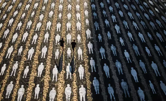 People walk through an installation marking the third anniversary of the Oct. 7, 2023, Hamas attack on Israel, on the beachfront in Tel Aviv, Israel, Wednesday, Oct. 7, 2026. (AP Photo/Oded Balilty)