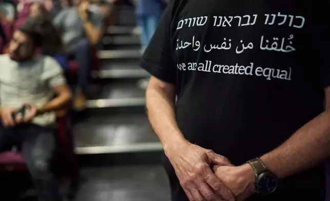 Oded Eisenberg wears a shirt that reads, in Hebrew, Arabic and English, "We are all created equal," while attending a Ra'am party campaign event in Tel Aviv, Israel, ahead of the country's general election, Friday, Oct. 23, 2026. (AP Photo/David Goldman)