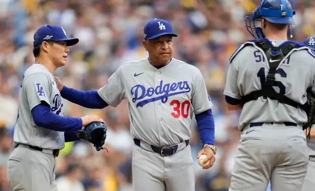 Los Angeles Dodgers manager Dave Roberts (30) pulls Los Angeles Dodgers pitcher Yoshinobu Yamamoto, left, as Los Angeles Dodgers catcher Will Smith, right, looks on from the game during the inning of Game 2 of baseball's National League Championship Series between the Milwaukee Brewers and the Los Angeles Dodgers, Monday, Oct. 12, 2026, in Milwaukee. (AP Photo/Ashley Landis)
