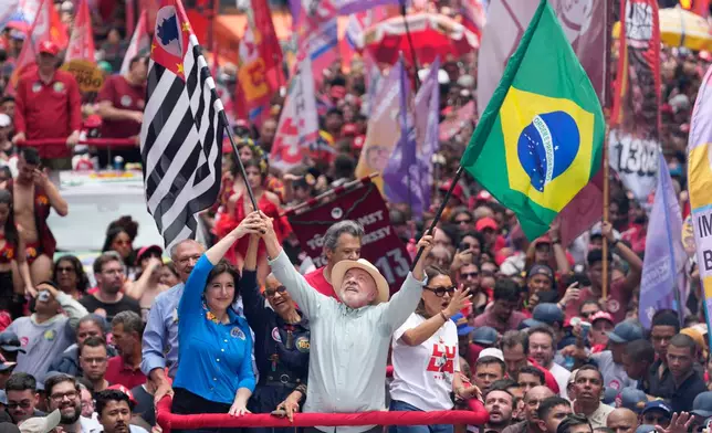 President Luiz Inacio Lula da Silva, who is running for reelection, waves a Brazilian and Sao Paulo state flags during a campaign rally a day ahead of the country's general election in Sao Paulo, Saturday, Oct. 3, 2026. (AP Photo/Andre Penner)