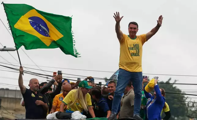 Opposition presidential candidate Flavio Bolsonaro waves to supporters during a campaign rally a day ahead of the country's general election, in Campo Grande, Rio de Janeiro state, Saturday, Oct. 3, 2026. (AP Photo/Bruna Prado)