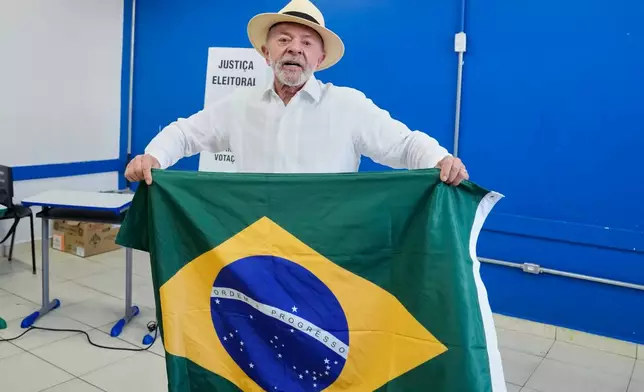 President Luiz Inacio Lula da Silva, who is running for reelection, displays a Brazilian flag after voting in Sao Bernardo do Campo, Brazil, Sunday, Oct. 4, 2026. (AP Photo/Andre Penner)