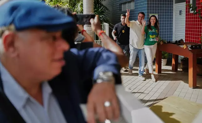 Opposition presidential candidate Sen. Flavio Bolsonaro accompanies his wife Fernanda Bolsonaro to vote during general elections in Rio de Janeiro, Sunday, Oct. 4, 2026.(AP Photo/Lucas Landau)