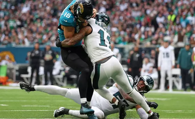 Jacksonville Jaguars quarterback Trevor Lawrence (16) is tackled by Philadelphia Eagles linebacker Jihaad Campbell (11) during an NFL football game in London, Sunday, Oct. 11, 2026. (AP Photo/Ian Walton)