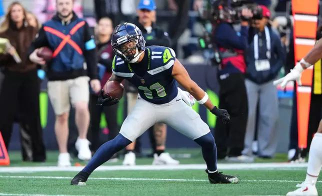 Seattle Seahawks wide receiver Jaxon Smith-Njigba makes a move on his way to scoring on a touchdown catch against the San Francisco 49ers during the second half of an NFL football game Sunday, Oct. 11, 2026, in Seattle. (AP Photo/Lindsey Wasson)