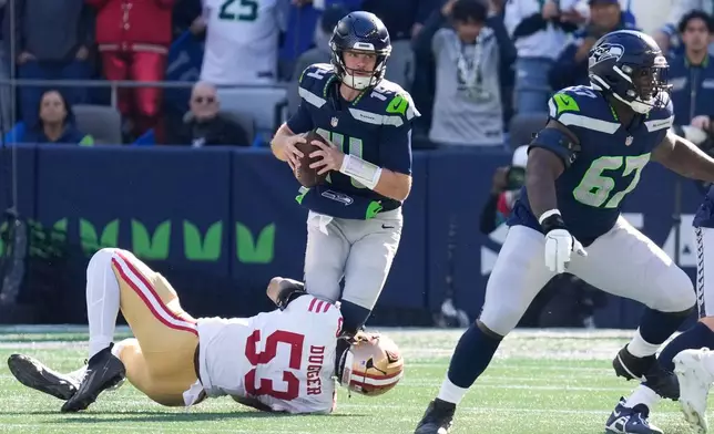 San Francisco 49ers linebacker Jaden Dugger (53) sacks Seattle Seahawks quarterback Sam Darnold (14) during the first half of an NFL football game Sunday, Oct. 11, 2026, in Seattle. (AP Photo/Stephen Brashear)