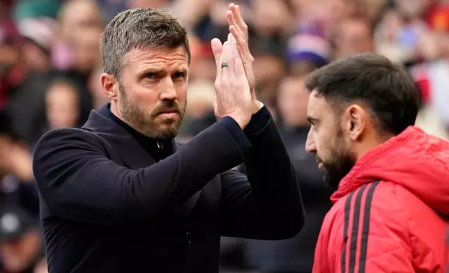 Manchester United's head coach Michael Carrick applauds to supporters ahead of the start of the English Premier League soccer match between Manchester United and Bournemouth in Manchester, England, Sunday, Oct. 25, 2026. (AP Photo/Dave Thompson)